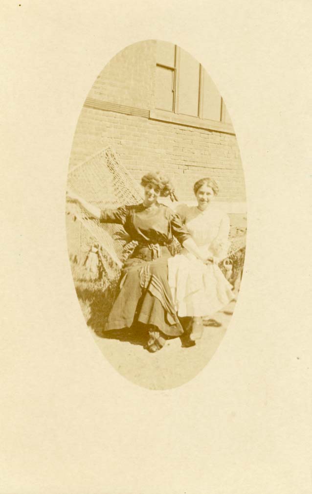 Two women in hammock holding hands postcard