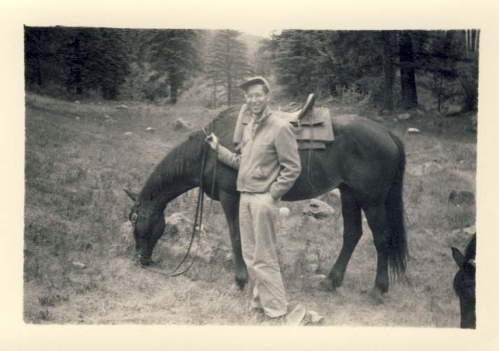 Horseman, standing beside horse photograph