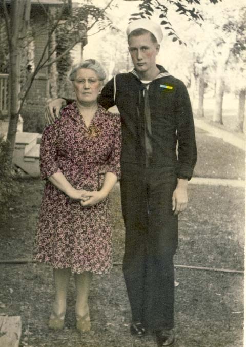 Mother standing beside son, dressed in navy outfit photograph
