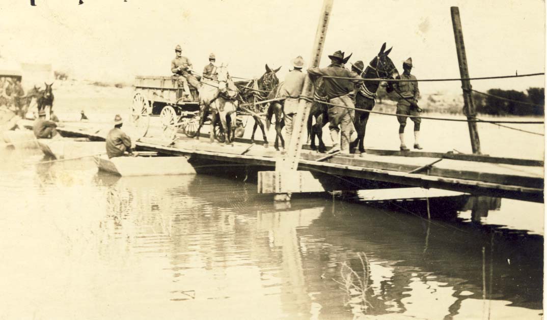 Men walking wagon across pontoon bridge postcard